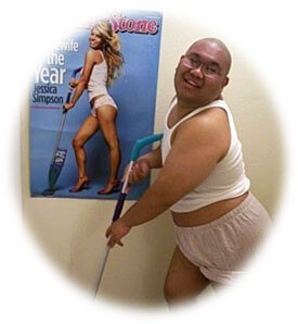 Funny bald guy posing by a vacuum cleaners poster